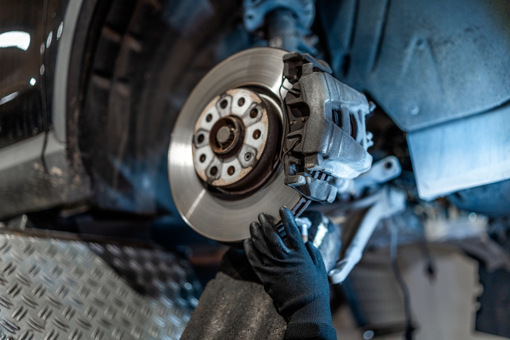 Close,Up,Of,Mechanic's,Hands,Wearing,Gloves,,Inspecting,Car,Brake