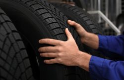 Male,Mechanic,With,Car,Tire,In,Auto,Store,,Closeup